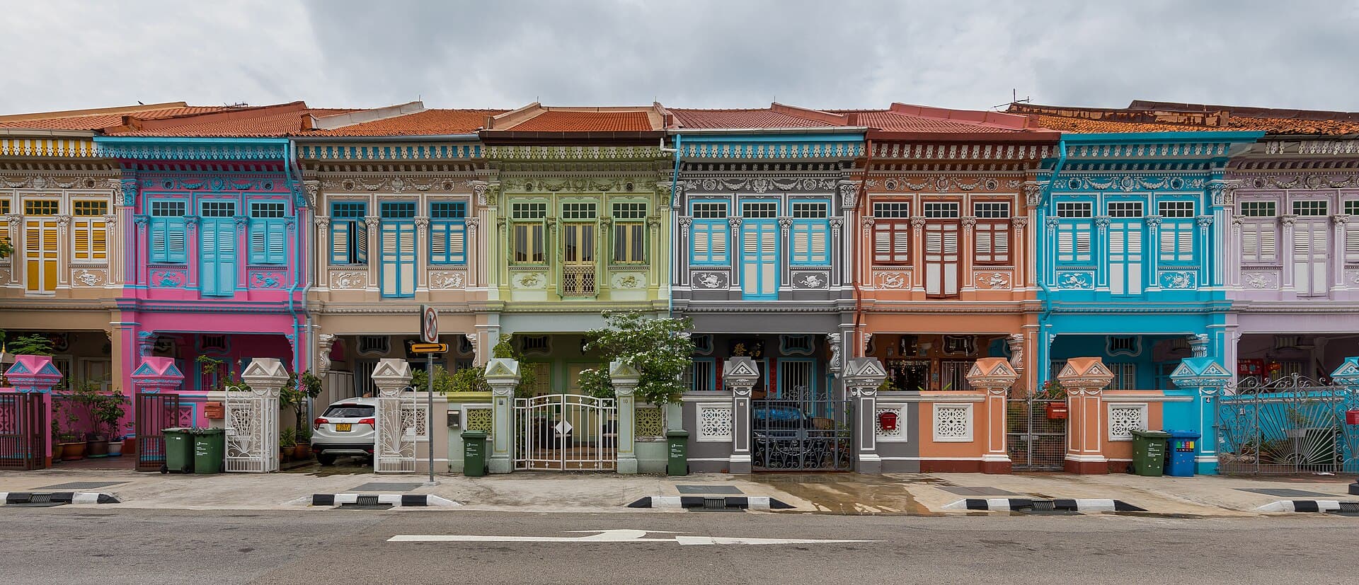 A row of pastel Peranakan shophouses on Koon Seng Road with decorative tiles, coloured shutters and five-foot ways