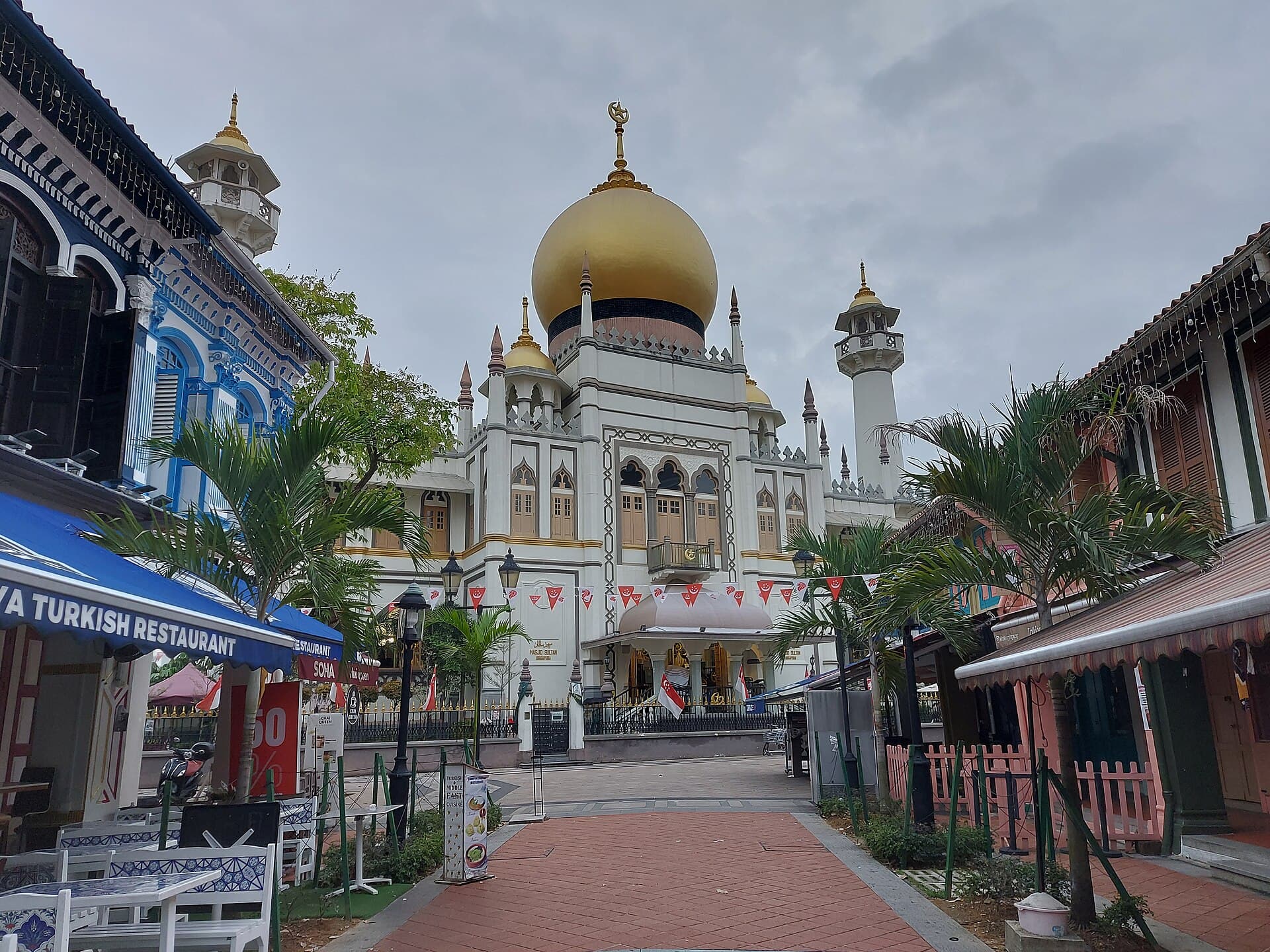 The golden onion dome and cream walls of Sultan Mosque rising above the shophouses of Kampong Glam