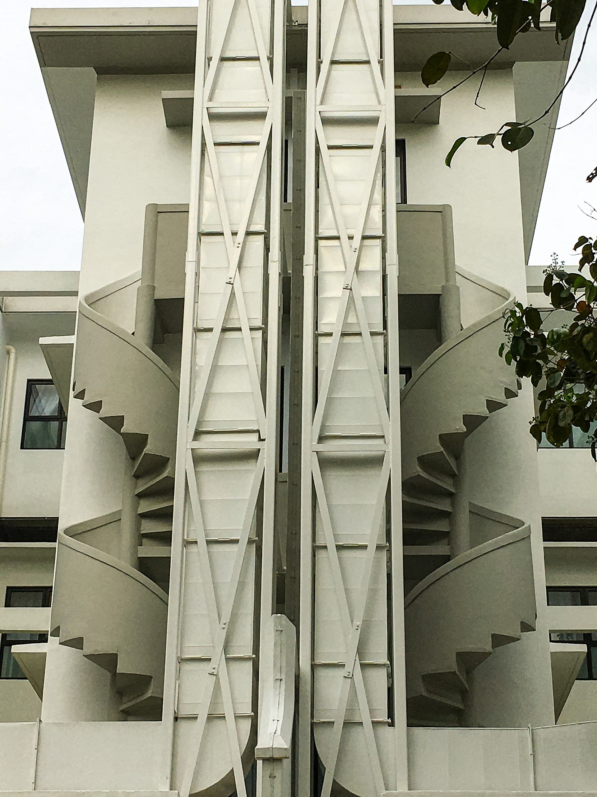 Low-rise pre-war flats along a Tiong Bahru street, with rounded balconies, parked cars and the estate’s compact, human scale